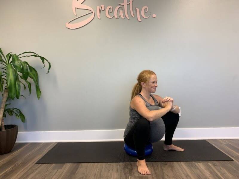Try standing in front of a chair and go into a squat position.   You do not have to go as low as pictured - even a teeny mini squat is effective.  As you lower your bottom to the floor, inhale and relax your pelvic floor. This is a good time to picture a baby coming out!  As you stand back up, exhale and gently let your pelvic floor recoil and squeeze your buttocks together.  
